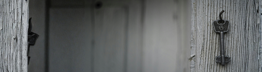 Chiave appesa su superficie in legno, simbolo del controllo su accesso ai fondi e gestione delle transazioni